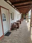 Überdachter Laubengang mit Sitzplätzen vor den Zimmern der Pension Assenheim